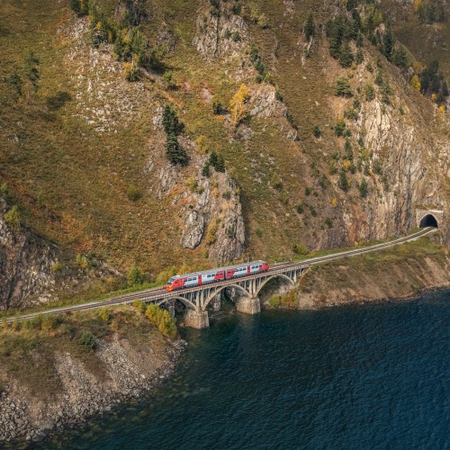 фотограф Сергей Крылов, ржд, лето, рельсовый автобус следует по берегу озера Байкал на фоне горы, озеро, лето, солнце, виадук, тоннель